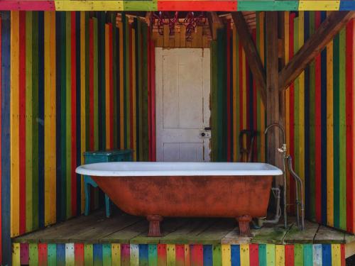 Cette chambre dispose d'une baignoire et d'un mur coloré. dans l'établissement Westacre Bradmoor & 4 Ton, à Narborough