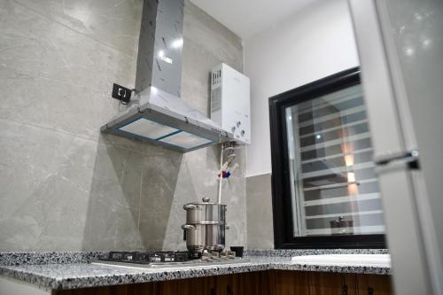 eine Küche mit einem Herd und einem Fenster in der Unterkunft Charming S1 cozy modern and bright in Mahdia