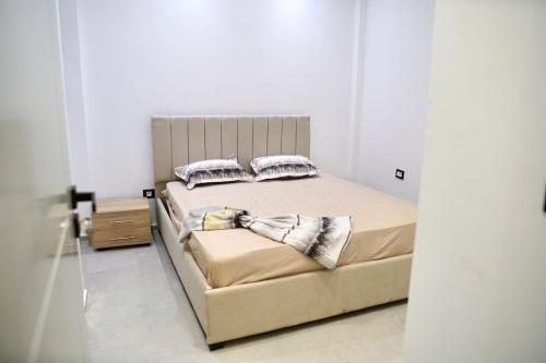 ein Bett mit zwei Kissen darauf in einem Schlafzimmer in der Unterkunft Charming S1 cozy modern and bright in Mahdia