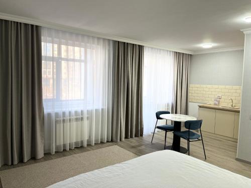 a hotel room with a bed and a table and chairs at 71 East Hotel in Astana