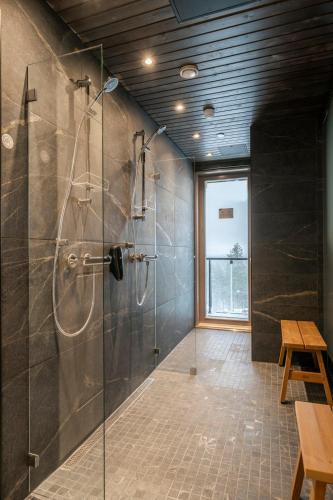 a bathroom with a shower with a glass door at Ski-Inn Kultakero Penthouse in Pelkosenniemi
