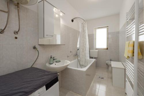a bathroom with a sink and a tub and a toilet at Casa Jurican in Višnjan