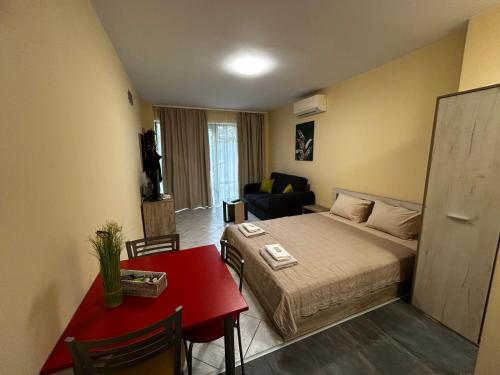 a small room with a bed and a red table at One room apartment 112 Аll-season в Св св Константин и Елена in Varna City