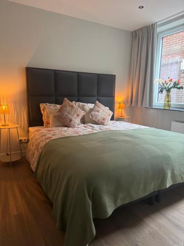 a bedroom with a large bed with a large headboard at Tante Ursula B&B in Venlo