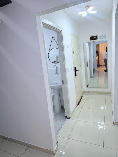a white bathroom with a sink and a mirror at GuestHouse16 in Kuito