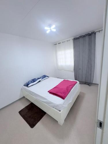 a white bedroom with a bed in a room at GuestHouse16 in Kuito