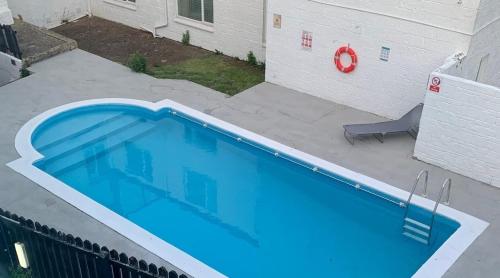 een groot blauw zwembad in een tuin bij Sunrise Hotel in Shanklin