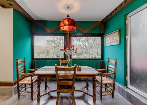 a dining room with green walls and a wooden table and chairs at Chalet Green in Tbilisi City