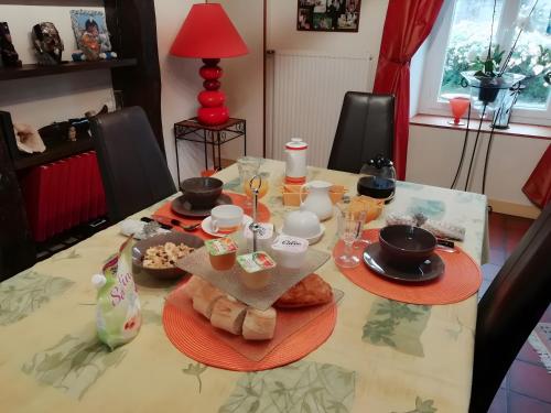 une table avec des assiettes, des tasses et de la nourriture dessus dans l'établissement Chambre Grany - Chambre, à Aucaleuc