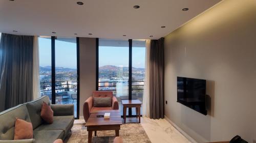 un soggiorno con un divano e una televisione di Merya Chalets - Al Shafa a Al Shafa