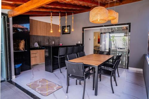 una cucina e una sala da pranzo con tavolo e sedie in legno di Bela casa de temporada em Alcobaça BA ad Alcobaça