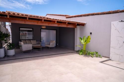 un patio di una casa con tavolo e sedie di Bela casa de temporada em Alcobaça BA ad Alcobaça