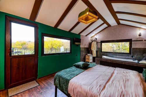 Dormitorio verde con cama y bañera en Chalet Green, en Tiflis