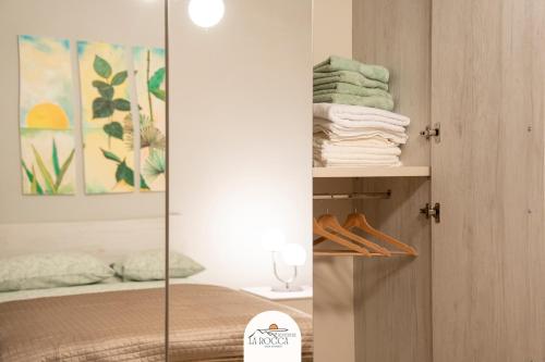 einen Spiegel in einem Schlafzimmer mit einem Bett und Handtüchern in der Unterkunft Belvedere la Rocca in Rocca dʼArce