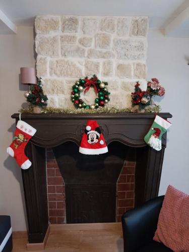 Elle comprend une cheminée ornée de décorations de Noël. dans l'établissement Les 4 Fils Aymon, à Bogny Sur Meuse
