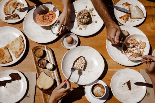 a group of people eating food on plates on a table at ALERÓ Seaside Skyros Resort in Skiros