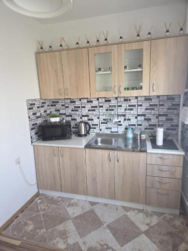 a kitchen with wooden cabinets and a sink at Studio apartman BF in Slavonski Brod
