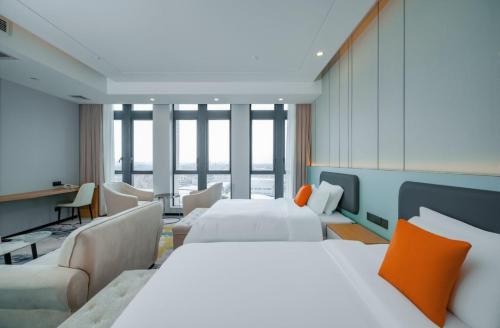 ein Hotelzimmer mit zwei Betten und einer Couch in der Unterkunft Wanlin International Hotel in Foshan