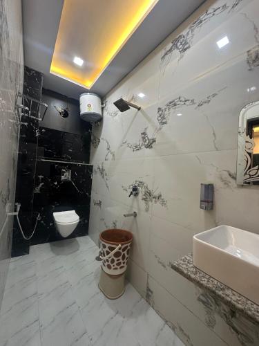 a bathroom with a sink and a toilet at Hotel Peepal Tree Prayagraj in Prayagraj