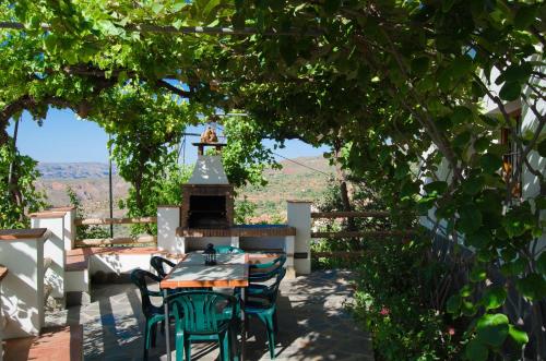 a patio with a table and chairs under a tree at Casa Número 1 in Válor