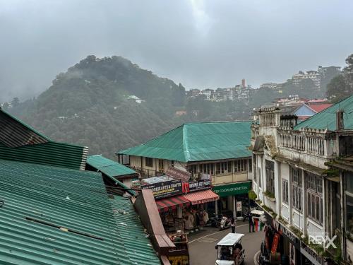 uma vista superior de uma cidade com edifícios e uma montanha em Park Woods At Mall Road em Mussoorie