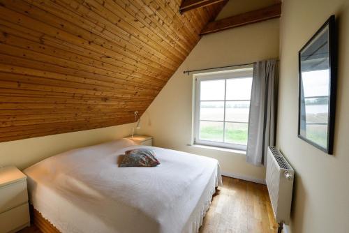 ein Schlafzimmer mit einem großen Bett und einer Holzdecke in der Unterkunft Remise - b55868 in Neuenkirchen