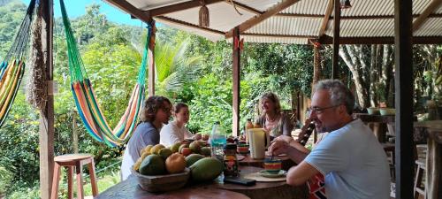 eine Gruppe von Menschen, die an einem Tisch mit einer Schale Obst sitzen in der Unterkunft Mirador Jungle El Macuti in Rurrenabaque