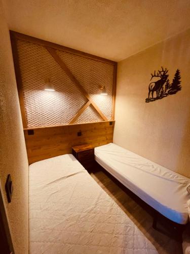 ein Schlafzimmer mit zwei Betten und einem Fenster mit einem Hirschaufkleber in der Unterkunft Appartement T2, 20m des Pistes, En Relooking in Les Angles
