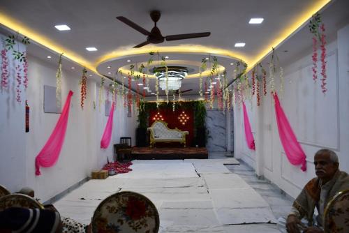un pasillo con decoración rosa y un sofá en una habitación en Hotel Peepal Tree Prayagraj, en Prayagraj