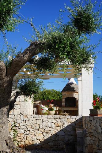 a tree in front of a stone wall at Trulli Pastore in Alberobello