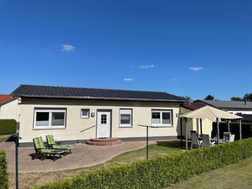 une maison avec une terrasse, une table et des chaises dans l'établissement Klosterwald, à Dargun