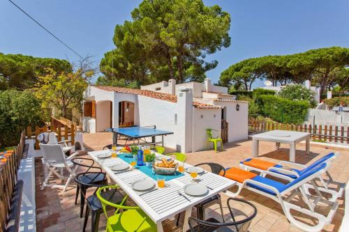 a patio with tables and chairs and a house at Villa Namibe na Quinta da Balaia in Albufeira