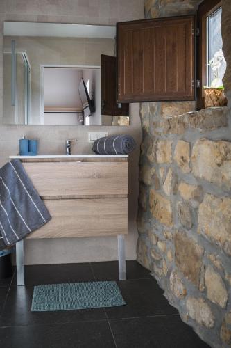 a kitchen with a sink and a stone wall at Arrutela in Hondarribia