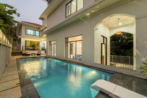 a swimming pool in the backyard of a house at SaffronStays Eden Greens in Calangute