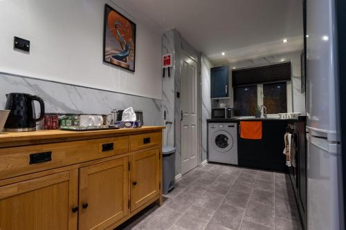 Il comprend une cuisine équipée d'un évier et d'un lave-linge/sèche-linge. dans l'établissement Charming 2 Bedroom luxurious Home in Thamesmead south east London, à North Woolwich