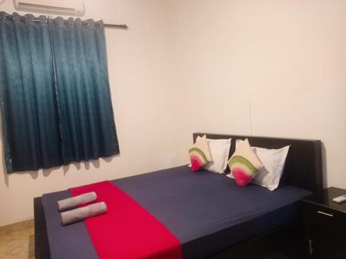 a bedroom with a red and blue bed with pillows at Tiny Villa Homestay - ONLY FOR FOREIGN BOOKINGS in Kurunegala