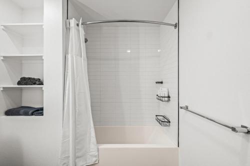 a shower with a shower curtain in a bathroom at Stylish Condo Mins to Shoreline in Long Beach