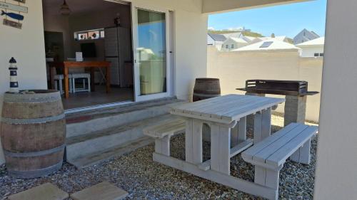 ein Picknicktisch und eine Bank vor einem Haus in der Unterkunft Nautilus Self Catering in Yzerfontein