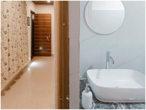 a bathroom with a white sink and a mirror at Lagoon Stays, Gokarna in Gokarna