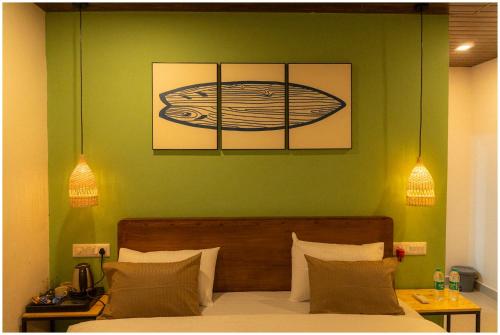 a bedroom with a bed with a green wall at Lagoon Stays, Gokarna in Gokarna