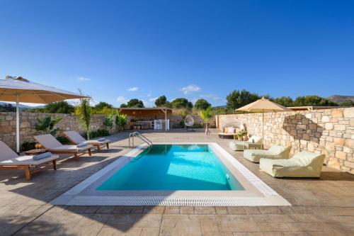 einen Pool in einem Garten mit Stühlen und einem Sonnenschirm in der Unterkunft Amora Pool Villas in Gennadi