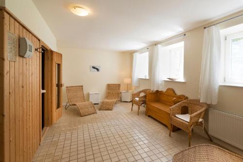 ein Wohnzimmer mit Couch und Stühlen in der Unterkunft Wohnung im zweiten Obergeschoss des Gutshauses in Neuenkirchen