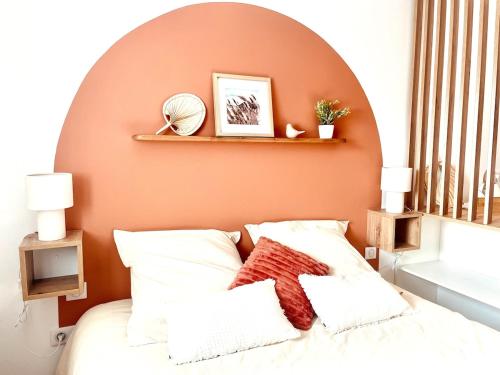 ein Schlafzimmer mit einer orangefarbenen Wand und einem Bett in der Unterkunft Le Cocon des rêves studio neuf avec terrasse et Parking in Wintzenheim