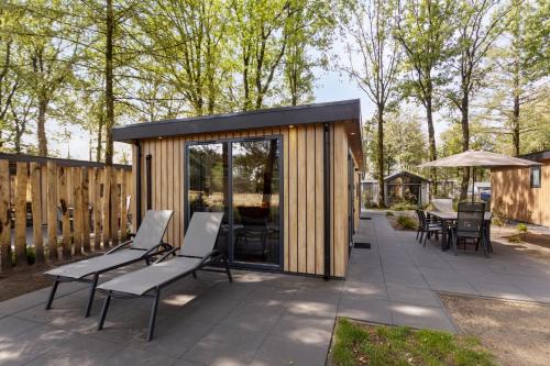 un pequeño cobertizo de madera con sillas y una mesa en Resort Veldhoven, en Veldhoven