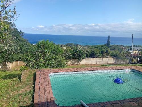 ein Swimmingpool mit dem Meer im Hintergrund in der Unterkunft Great sea view, swimming pool, braai, wi-fi in Port Shepstone