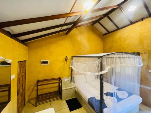 a room with a bed and a yellow wall at Silver Shine Beach Resort in Kalpitiya