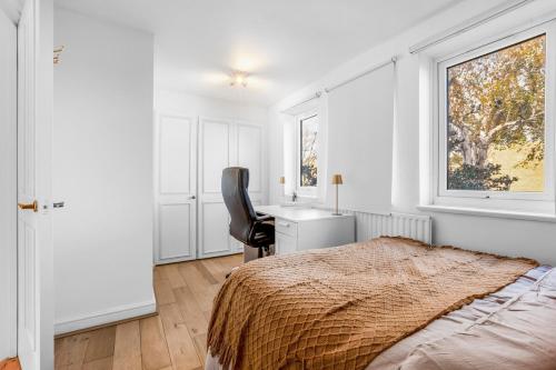 a bedroom with a bed and a desk and a chair at Parking Outside Terrace Balcony Fulham ST in London