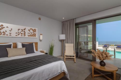 a bedroom with a bed and a view of a pool at Hotel St.John Suites Adults Only in Tsilivi