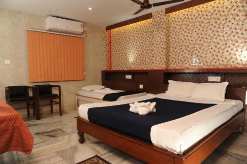 ein Schlafzimmer mit zwei Betten und einem Schreibtisch darin in der Unterkunft Sonar Bangla's Motel Midway in Howrah