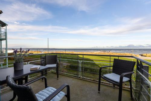 a balcony with chairs and tables and a view of the ocean at Dorfring 36 Seeadler in Stein